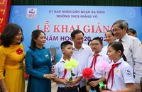 Đồng chí Vương Đình Huệ, Uỷ viên Bộ Chính trị, Bí thư Thành uỷ với các thầy cô giáo và các em học sinh Trường THCS Giảng Võ (Ảnh: DUY LINH)