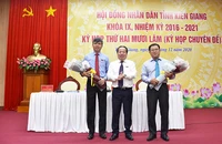 Ông Nguyễn Lưu Trung (trái) nhận hoa chúc mừng của Thường trực HĐND tỉnh Kiên Giang.