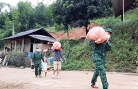 Bộ đội Biên phòng Na Mèo giúp người dân di chuyển khỏi khu vực sạt lở đất.