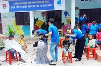 Bộ đội và thanh niên cắt tóc cho các em nhỏ trên cổng trời Cha Lo.