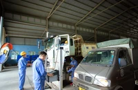 Các đăng kiểm viên kiểm định phương tiện tại một dây chuyền kiểm định xe cơ giới ở Hà Nội.