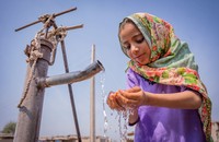Một cô bé đang uống nước từ máy bơm tay tại Pakistan. Nguồn: UN