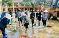 Giáo viên cùng các phụ huynh học sinh trường Minh Chuẩn, huyện Lục Yên vệ sinh sân trường sau bão số 3. (Ảnh: THANH SƠN)