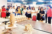 Chủ tịch Hiệp hội Thủ công mỹ nghệ và làng nghề Hà Nội Hà Thị Vinh giới thiệu với khách tham quan về gốm Bát Tràng (huyện Gia Lâm).