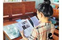Chị Trần Thị Vy cùng với hồ sơ bệnh án tai biến do tiêm nâng mũi.