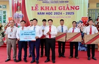 Phó Thủ tướng Lê Thành Long (phải) tặng 5 bộ máy vi tính cho Trường tiểu học và trung học cơ sở Tuân Đạo, huyện Lạc Sơn.