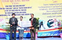 Đại diện lãnh đạo Ủy ban nhân dân tỉnh Quảng Bình trao bảng tượng trưng các công trình dân sinh tặng cho cụm bản Lẳng Khăng (Lào)