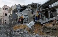 Chim bồ câu bay qua đống đổ nát của những ngôi nhà bị phá hủy trong các cuộc không kích của Israel, ở Khan Younis, phía nam dải Gaza, ngày 11/10/2023. (Ảnh: Reuters)