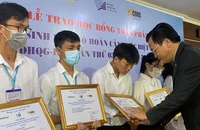 PGS, TS Nguyễn Đình Tứ, Giám đốc Quỹ Phát triển Đại học Quốc gia Thành phố Hồ Chí Minh trao học bổng cho các em sinh viên.