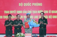 Thượng tướng Hoàng Xuân Chiến trao Quyết định của Chủ tịch nước và tặng hoa chúc mừng Trung tá Đặng Quốc Tuấn. 