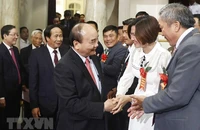 Chủ tịch nước Nguyễn Xuân Phúc với các đại biểu tham dự buổi lễ. (Ảnh: TTXVN)