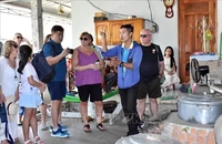 Các du khách Tàu Spectrum of the Seas hào hứng, thích thú khi tham quan nghề nấu rượu truyền thống tại TP Bà Rịa, tỉnh Bà Rịa-Vũng Tàu ngày 26/2. (Ảnh: TTXVN)