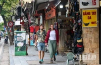 Du khách nước ngoài rảo bước trên phố Hàng Đào, Hà Nội. (Ảnh: NHẬT QUANG)