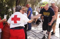 Một tình nguyện viên của dịch vụ y tế khẩn cấp tại Hy Lạp phát nước miễn phí cho du khách tại thành cổ Acropolis hôm 14/7. (Ảnh: REUTERS) 