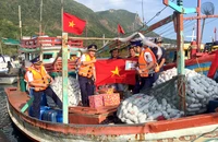 Cán bộ Bộ Tư lệnh Cảnh sát biển trao cờ Tổ quốc và quà tặng ngư dân tại cảng Bến Đầm, huyện Côn đảo, tỉnh Bà Rịa-Vũng Tàu.