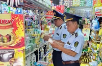 Cán bộ Cục Quản lý thị trường tỉnh Kiên Giang kiểm tra hàng hóa tại một cơ sở kinh doanh. (Ảnh MINH TRANG)
