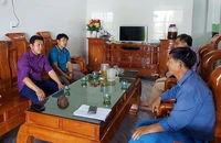 Cán bộ lãnh đạo xã Quảng Đông, huyện Quảng Trạch (Quảng Bình) trò chuyện với một hộ dân ở khu tái định cư thôn Vịnh Sơn.