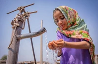 Một cô bé đang uống nước từ máy bơm tay tại Pakistan. Nguồn: UN