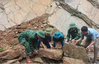 Cán bộ chiến sĩ Đồn Biên phòng Mường Ải phối hợp với các lực lượng và nhân dân khắc phục tình trạng đá sạt lở gây ách tắc giao thông, mất an toàn trên tuyến đường qua địa bàn.