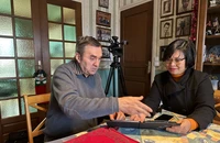 Ông Michel Strachinescu chia sẻ với phóng viên những bức ảnh kỷ niệm khi ông còn là lái xe cho Phái đoàn Việt Nam. (Ảnh: Thu Hà - P/v TTXVN tại Pháp) 