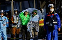 Người dân choàng chăn bạc giữ nhiệt theo dõi hoạt động cứu nạn tại thành phố Wajima, tỉnh Ishikawa, Nhật Bản, ngày 3/1/2024. (Ảnh: REUTERS)