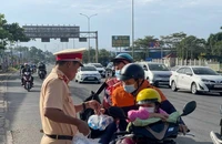 Lực lượng Cảnh sát giao thông phát nước giúp người tham giao thông trên đường về quê đón Tết Nguyên đán 2023. 