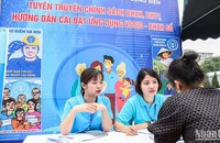 Cán bộ Bảo hiểm xã hội quận Long Biên, Hà Nội giới thiệu chính sách với người lao động. (Ảnh: NGÂN ANH)