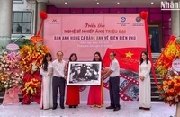Đạo diễn Triệu Tuấn (người cầm ảnh bên phải) đại diện gia đình cố Nghệ sĩ nhiếp ảnh Triệu Đại trao tặng bộ ảnh cho Bảo tàng Phụ nữ Việt Nam.