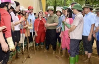 Thủ tướng Phạm Minh Chính thăm hỏi, động viên các cô giáo Trường Mầm non Hoa Lan (thành phố Yên Bái) đang dọn dẹp bùn đất tại trường. (Ảnh: Trần Hải)