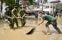 Các lực lượng quân đội và công an giúp nhân dân dọn dẹp vệ sinh môi trường sau bão lũ tại thành phố Yên Bái (Ảnh: TRẦN HẢI). 