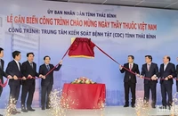 Các đại biểu thực hiện nghi thức gắn biển công trình chào mừng Ngày Thầy thuốc Việt Nam cho tòa nhà CDC Thái Bình.