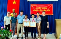 Phó Giám đốc Sở Giáo dục và Đào tạo tỉnh Đồng Nai Đỗ Đăng Bảo Linh tặng Giấy khen cho 2 em học sinh.
