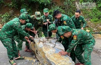 Cán bộ, chiến sĩ Đồn Biên phòng Chiềng Tương, Bộ đội Biên phòng tỉnh Sơn La khắc phục tuyến đường bị đá sạt lở chắn ngang.