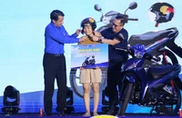Bí thư Trung ương Đoàn Ngô Văn Cương và Tổng Giám đốc TCPVN Nguyễn Thanh Huân trao giải chiếc xe máy giải đặc biệt chương trình bốc thăm trúng thưởng tặng nữ thanh niên công nhân may mắn. 