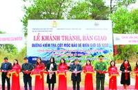 Lãnh đạo các đơn vị cắt băng khánh thành công trình đường kiểm tra cột mốc biên giới số 1232. (Ảnh Ngọc Hiếu)