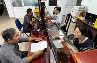 Người dân thực hiện thủ tục hành chính tại Ủy ban nhân dân Phường 6 (quận Bình Thạnh, Thành phố Hồ Chí Minh) trước thời điểm phường này sáp nhập với Phường 7. (Ảnh QUANG QUÝ)