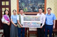 Đồng chí Phạm Song Hà, Ủy viên Ban Biên tập, Trưởng Ban Chính trị - Xã hội tặng phụ san cho trưởng nhóm tác giả.