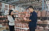 Nghệ nhân Nguyễn Mạnh Hòa (phải) giới thiệu những sản phẩm mới với du khách.