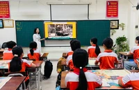 Trình chiếu phụ san đặc biệt của Báo Nhân Dân trong giờ sinh hoạt ngoại khóa tại Trường tiểu học Suối Hoa, thành phố Bắc Ninh.
