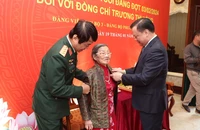 Bí thư Thành ủy Hà Nội Đinh Tiến Dũng trao Huy hiệu cho đảng viên lão thành.