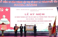 Thừa ủy nhiệm, Chủ tịch Ủy ban nhân dân tỉnh Bình Dương Võ Văn Minh (thứ 2 từ trái sang) trao Huân chương Lao động hạng Nhất cho lãnh đạo thành phố Tân Uyên.