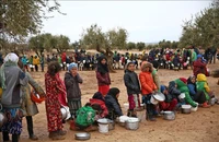 Trẻ em xếp hàng chờ nhận thức ăn cứu trợ tại trại tị nạn ở Aleppo, Syria. (Ảnh tư liệu: AFP/TTXVN)