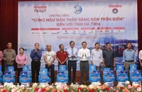 Đại diện lãnh đạo tỉnh Hà Tĩnh và báo Pháp Luật Thành phố Hồ Chí Minh trao quà cho bà con ngư dân. (Ảnh: ĐẶNG TRUNG)
