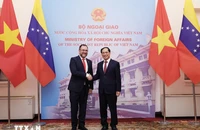 Bộ trưởng Ngoại giao Bùi Thanh Sơn với Bộ trưởng Ngoại giao Cộng hòa Boliva Venezuela Yvan Gil Pinto. (Ảnh: TTXVN)