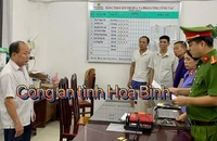 Nguyễn Văn Lâm, Giám đốc chi nhánh Văn phòng đăng ký đất đai huyện Lạc Sơn (trái). (Ảnh: Công an cung cấp).