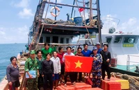 Tổ công tác tuyên truyền kết hợp tặng cờ tổ quốc cho ngư dân.