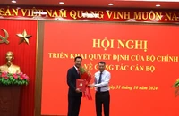 Đồng chí Lê Minh Hưng, Ủy viên Bộ Chính trị, Bí thư Trung ương Đảng, Trưởng Ban Tổ chức Trung ương trao quyết định, tặng hoa cho đồng chí Lê Ngọc Quang.
