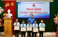 Phó Bí thư Tỉnh Đoàn, Chủ tịch Hội đồng Đội tỉnh Quảng Bình Đinh Trung Hiếu trao tặng Huy hiệu tuổi trẻ dũng cảm cho 5 đội viên.