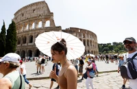 Khách du lịch đi bộ gần Đấu trường La Mã tại Rome trong đợt nắng nóng lan rộng khắp Italia, ngày 17/7/2023. (Ảnh: REUTERS)