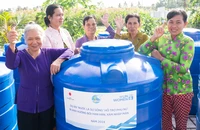 Phụ nữ Cà Mau nhận bồn chứa nước sinh hoạt trong khuôn khổ dự án “Nước là sự sống”.